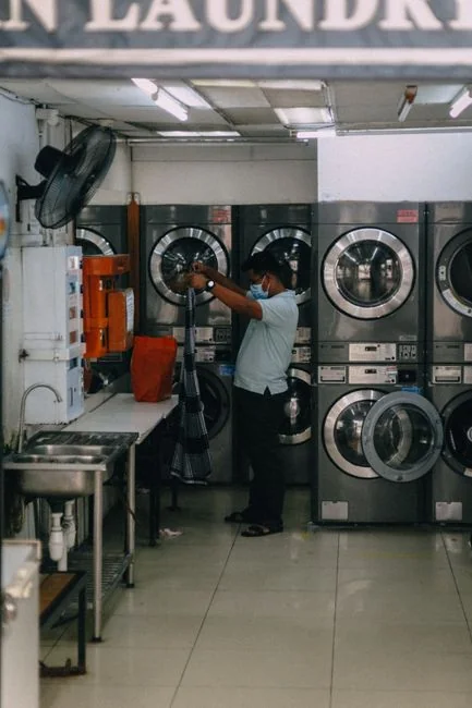 A woman wearing headphones cleaning inside, with plants all around her.